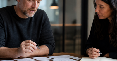 Editorial-style business scene showing a founder-operator and colleague reviewing how work moves through a growing company.